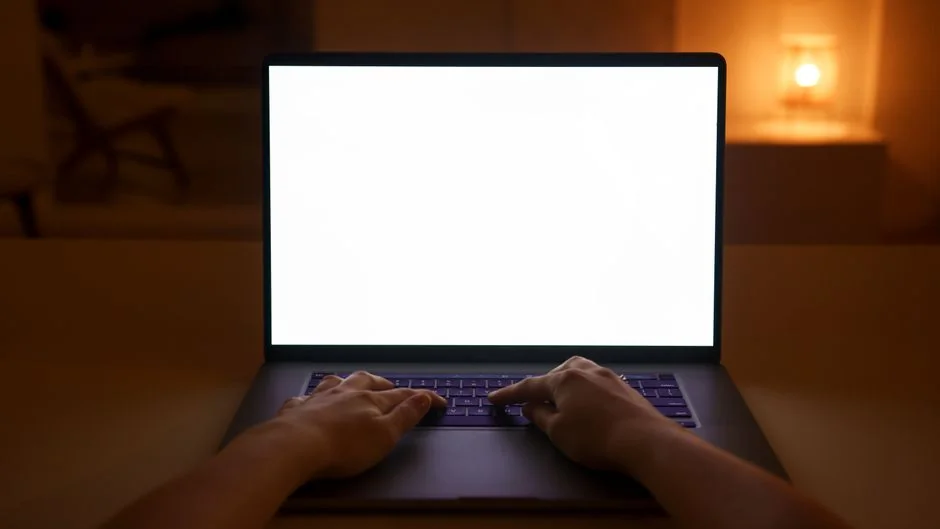 Woman in floral dress shopping online with a laptop and credit card indoors.